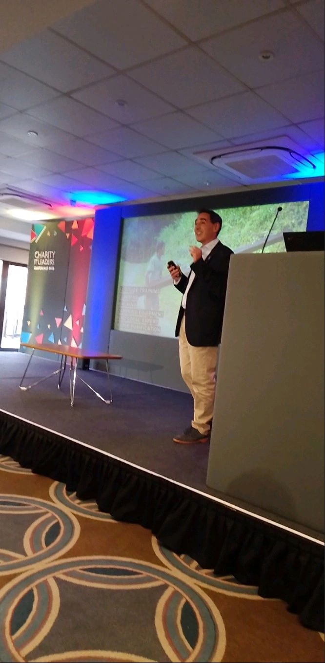 picture of Stuart speaking on stage at a conference